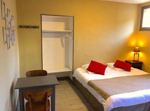a room with two beds with red pillows on them at L'Estaminet in Mazille