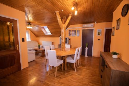 BalatonszentgyörgyにあるFarkas Guesthouseのダイニングルーム(木製テーブル、白い椅子付)