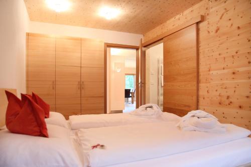 a bedroom with two beds with white sheets and red pillows at ZeiTraum Ferienwohnung Braunhörnle in Elzach