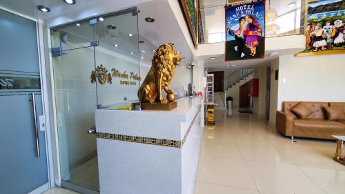 a lobby with a statue of a lion on a counter at Hotel Wanka Palace in Huancayo