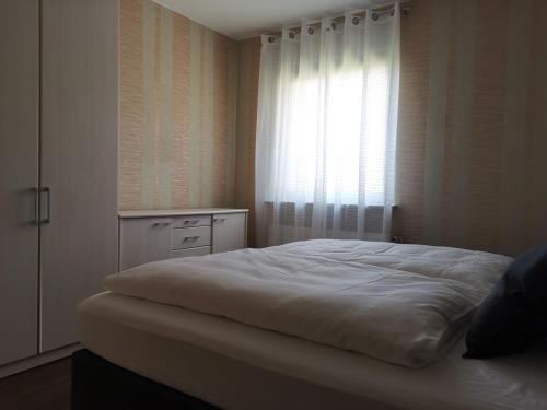 una camera con un letto bianco e una finestra di Quiet apartment with green view in urban location a Braunschweig