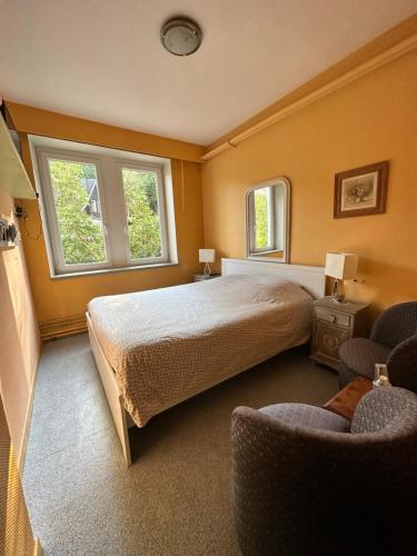 ラ・ロシュ・アン・アルデンヌにあるホテル ル ロイヤル ルクセンブルグのベッドルーム1室(大型ベッド1台、窓2つ付)