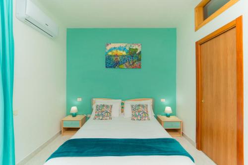a bedroom with blue walls and a bed with pillows at Tra I Monti in Tramonti