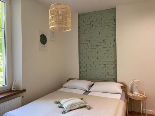 um quarto com 2 camas e uma parede de tijolos em Cozy and bright Šaulių studio in Klaipeda em Klaipėda