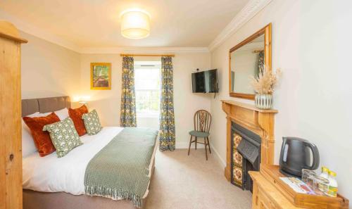 um quarto com uma cama, uma televisão e uma lareira em Cross Keys Inn Ettrickbridge em Ettrickbridge End