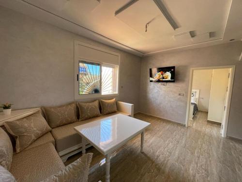 ein Wohnzimmer mit Couch und Tisch in der Unterkunft DAR RAS EL MA PLAGE in Ras El Ma