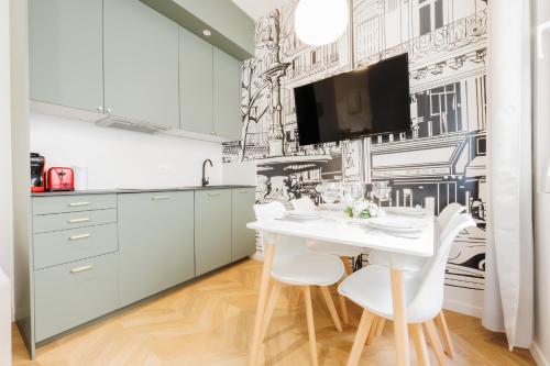 - une cuisine avec une table et des chaises blanches dans l'établissement Charming Apartment - 1BR - Guy Moquet, à Paris