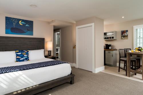 a bedroom with a large bed and a kitchen at The Inn at Cape Cod in Yarmouth Port