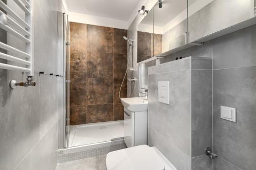 ein Bad mit einem WC, einer Dusche und einem Waschbecken in der Unterkunft Kamienica Centrum Apartament nr 14 in Stettin