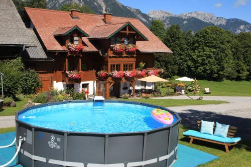 a house with a swimming pool in front of a house at Biobauernhof Brandlhof in Ramsau am Dachstein