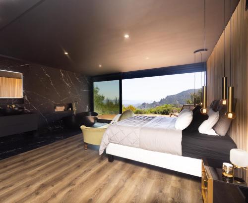 une chambre avec un grand lit et une grande fenêtre dans l'établissement Villa Linda Vista, à Fréjus