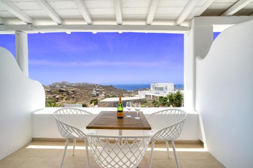 a table and chairs on a balcony with a view of the ocean at Anius Apartments in Mýkonos City