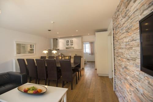 a living room and dining room with a dining table and a television at Haus Wasmer by AlpenTravel in Bad Hofgastein