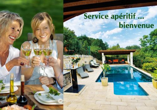 a woman holding a glass of wine next to a pool at Villa 'Deux Couples' dans le Paradis des Gourmands, de paix et de quiétude - inclus Soirée Dégustation Vin & Viande in Saint-Jean-de-Côle
