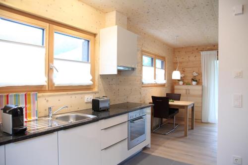 a kitchen with a sink and a table with chairs at ZeiTraum Ferienwohnung Hohe Stein in Elzach