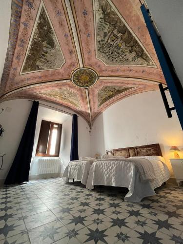 a bedroom with a ceiling with paintings on it at El palacete azul in Almendral