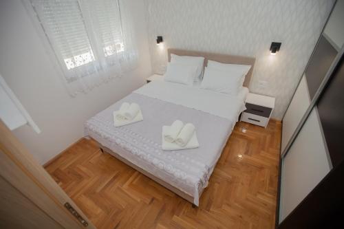 a bedroom with a bed with two white towels on it at Apartman Lena in Trebinje