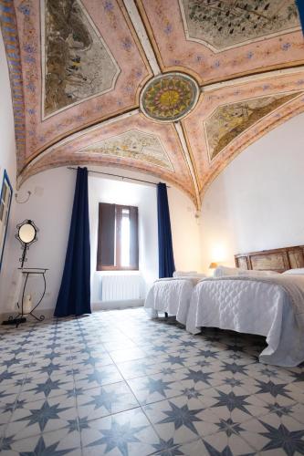 um quarto amplo com um tecto com pinturas em El palacete azul em Almendral