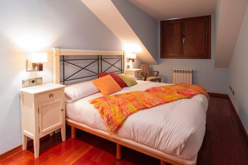 ein Schlafzimmer mit einem großen Bett und einem Nachttisch in der Unterkunft Apartamentos Casa Miño in Pola de Somiedo