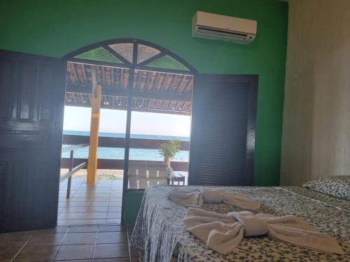 1 dormitorio con 1 cama y vistas al océano en Pousada Princesa do Mar, en Tamandaré
