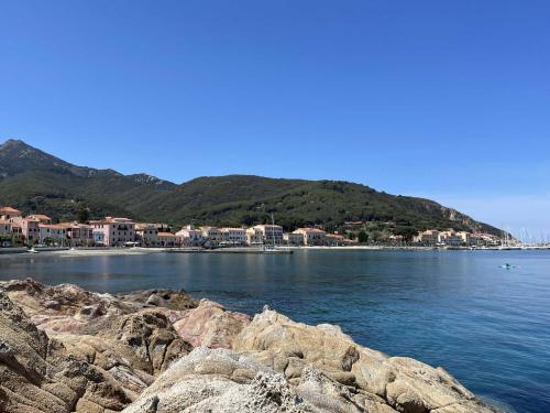 vista su una cassa d'acqua con case e montagne di Casa Mareluna - ArgonautiVacanze a Marciana Marina