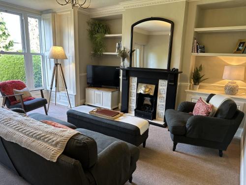 a living room with a fireplace and a mirror at The Beeches - Chatsworth Apartment No 1 - Sleeps 2 in Baslow