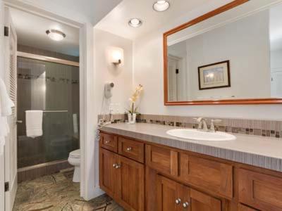 a bathroom with a sink and a toilet and a mirror at Kiahuna Plantation Resort Kauai by OUTRIGGER in Koloa