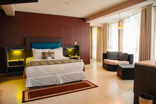 a bedroom with a large bed and a living room at Camino Plaza in Cochabamba
