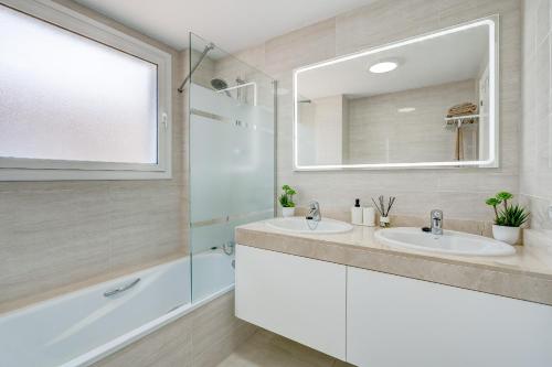 La salle de bains est pourvue de 2 lavabos, d'une douche et d'un miroir. dans l'établissement Casa del Sol, à Puerto de Santiago