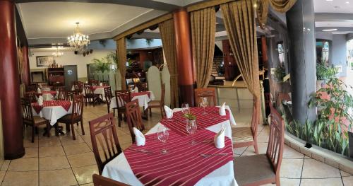 a dining room with a table with red and white table cloth at Faraona Grand Hotel in Lima