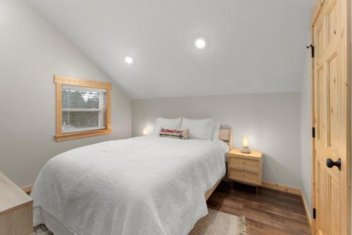 Un dormitorio con una cama blanca y una ventana. en Little Tooth Retreat, en Sandpoint