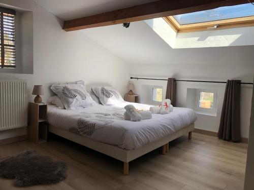 a bedroom with a bed with two stuffed animals on it at Chambres d'Hôtes de Marchet in Auvillar