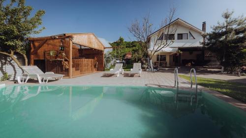 a swimming pool in a yard with a house at Căsuța de sub deal - Ciubăr și piscină in Măgura