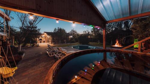 a backyard with a swimming pool and a fire place at Căsuța de sub deal - Ciubăr și piscină in Măgura