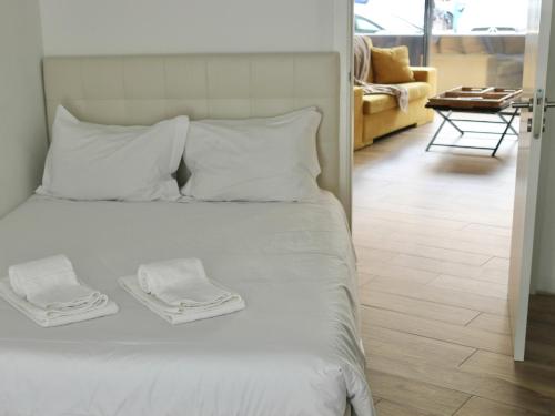a bedroom with a white bed with two towels on it at Up iConik in Aveiro