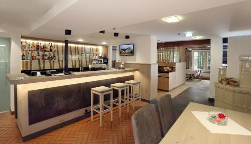 a restaurant with a bar with stools in a room at Schäfle Landgasthof in Feldkirch