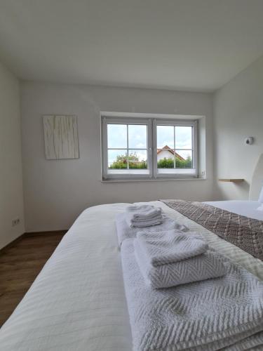 um quarto branco com uma cama com toalhas em Private Zimmer in Neubau Familienhaus em Alsfeld