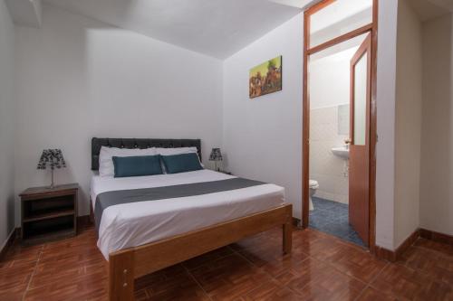 1 dormitorio con 1 cama grande y baño en Ayenda Hostal Cusco Sol, en Cusco