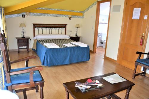 1 dormitorio con 1 cama, mesa y sillas en Hostal Infanta Doña Leonor, en Palencia