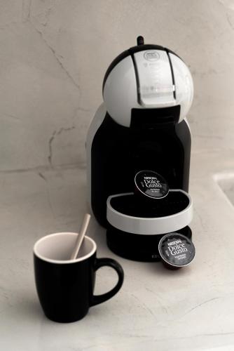a coffee maker and a cup of coffee on a counter at Aerenia Luxury Suites in Karterados