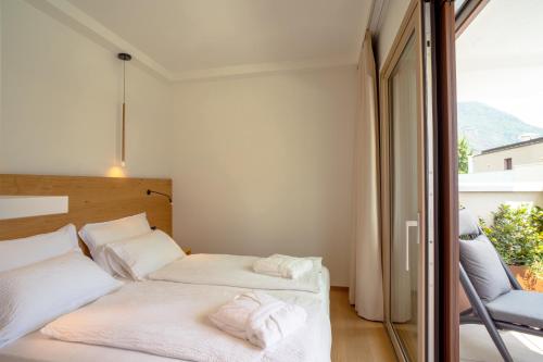 a bedroom with two beds and a balcony at Wellness Smart Suites in Bolzano