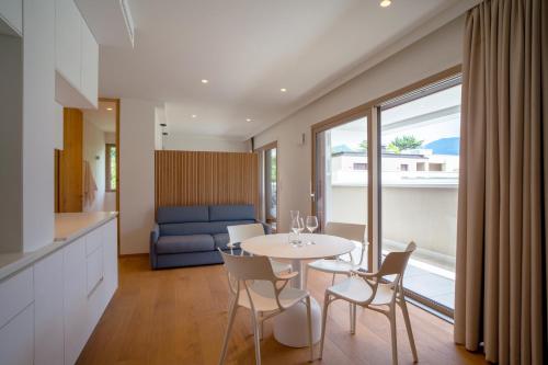 a kitchen and living room with a table and chairs at Wellness Smart Suites in Bolzano