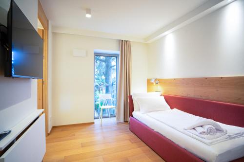 a hotel room with a bed and a flat screen tv at Wellness Smart Suites in Bolzano