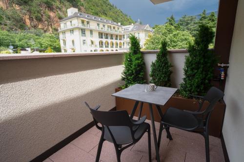 a balcony with a table and chairs and a building at Wellness Smart Suites in Bolzano