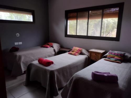 a room with three beds and a window at La Pasionaria Casa de Campo in Agua de Oro