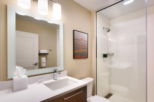 a bathroom with a sink and a toilet and a mirror at TownePlace Suites by Marriott Salt Lake City Draper in Draper