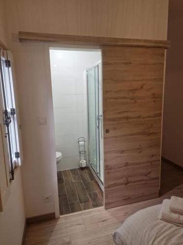 1 dormitorio con puerta corredera que conduce a un baño en La Havane, en Givry