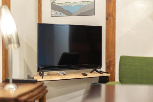 a flat screen tv sitting on a wooden stand at Popotel 2 KURA in Matsumoto