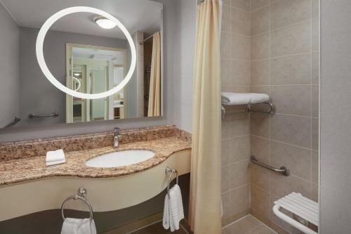 La salle de bains est pourvue d'un lavabo et d'un miroir. dans l'établissement Courtyard by Marriott Tbilisi, à Tbilissi