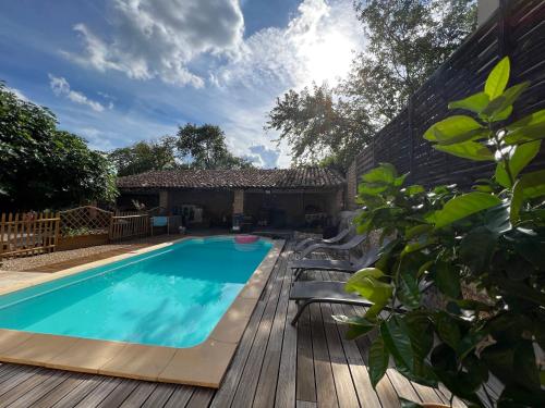 une piscine avec une terrasse et une maison dans l'établissement Magnanerie avec piscine en Coeur de village, à Canaules-et-Argentières